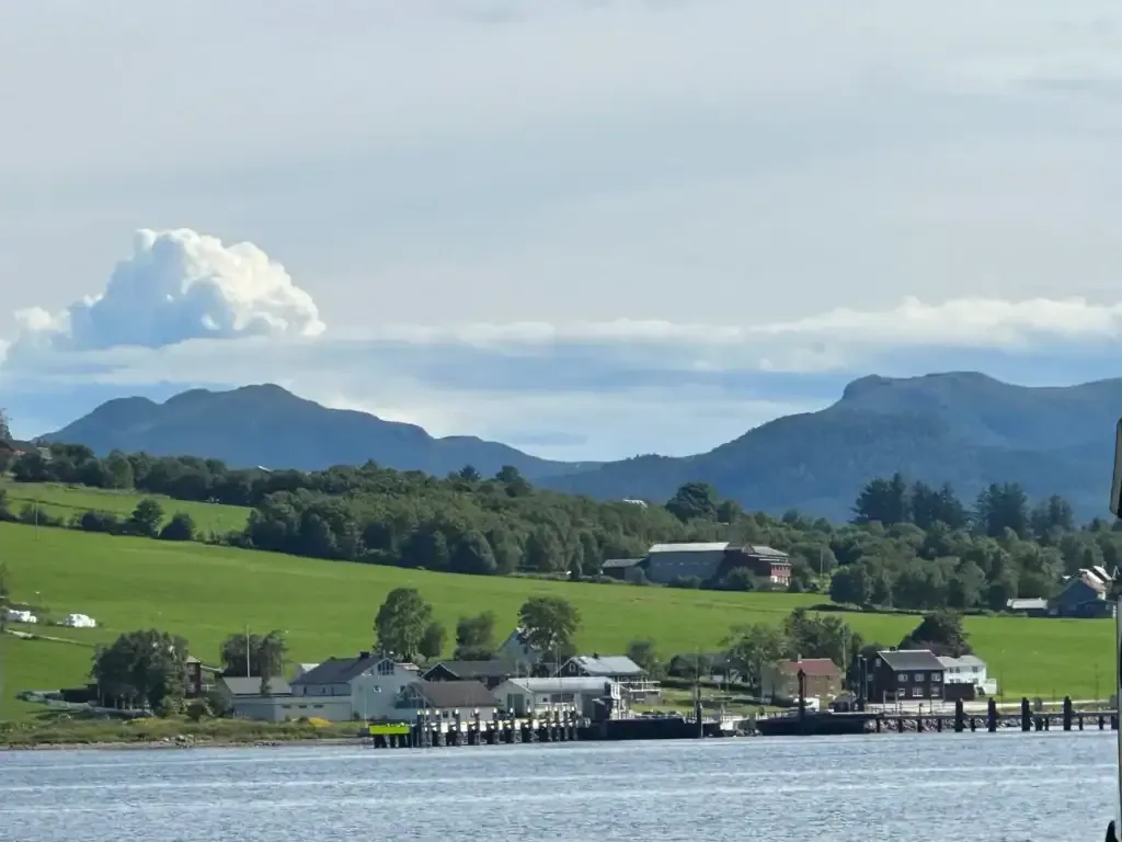 Kystlandskap med fjell, gårder og sjø